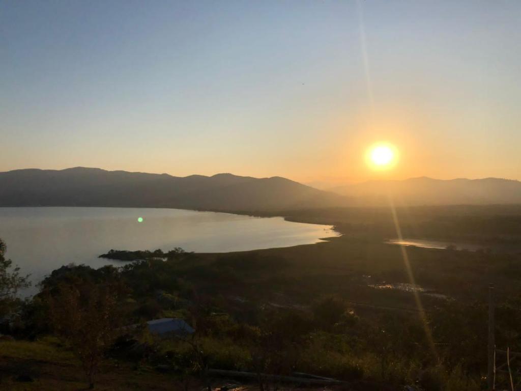 a sunset over a body of water with the sun setting at Sitio do Ma Vio in Governador Celso Ramos