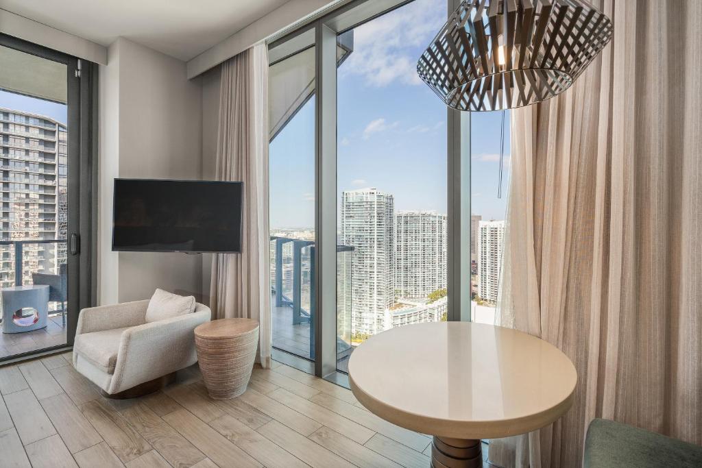 a living room with a table and a large window at EAST Miami in Miami