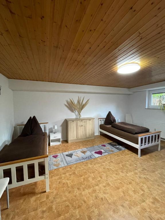 a bedroom with two beds and a wooden ceiling at Ferienwohnung Juco in Heddesheim