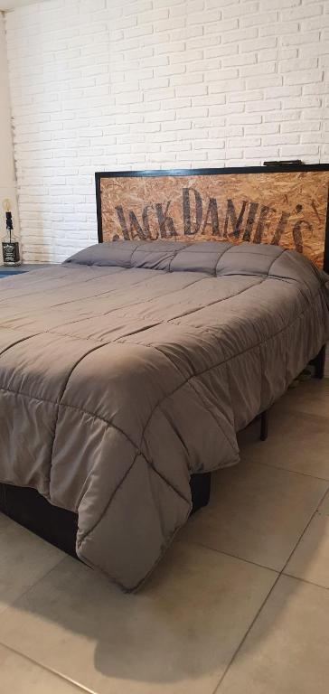 a bed with a brown comforter with the words kick demand on it at Rock Apart in Puerto Madryn