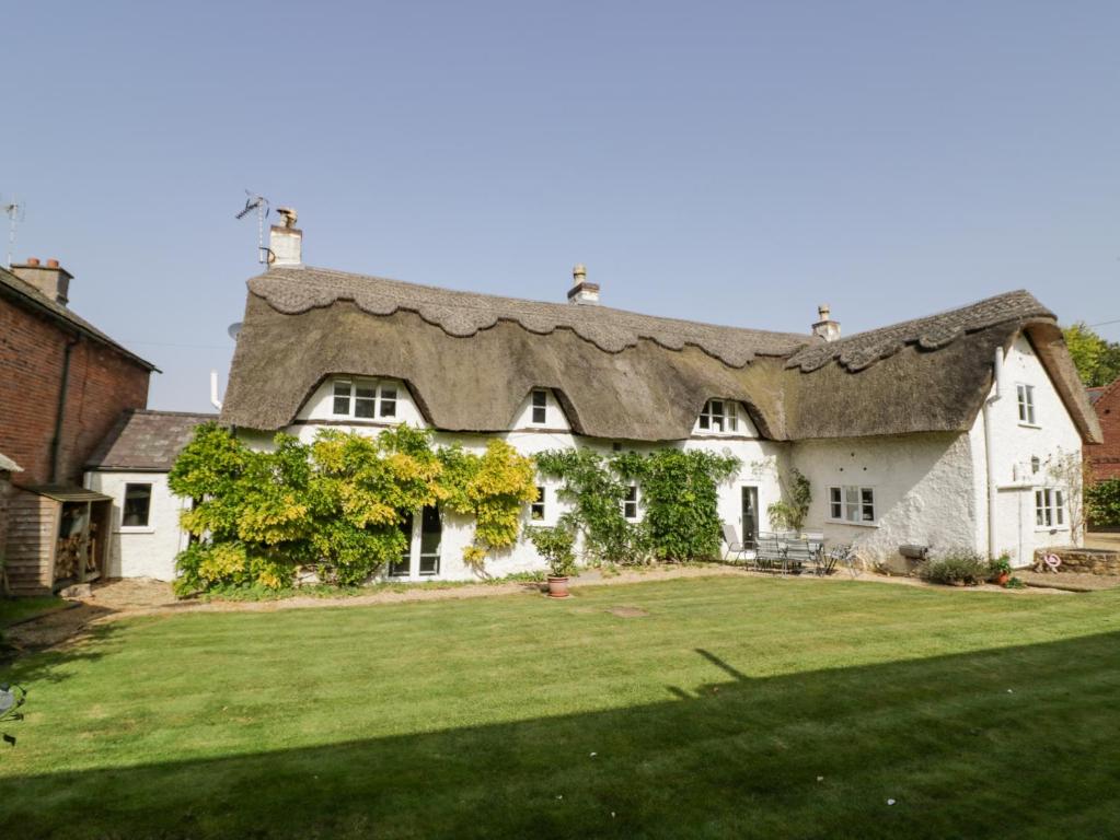 a large white house with a thatched roof at Millstone House in Lutterworth