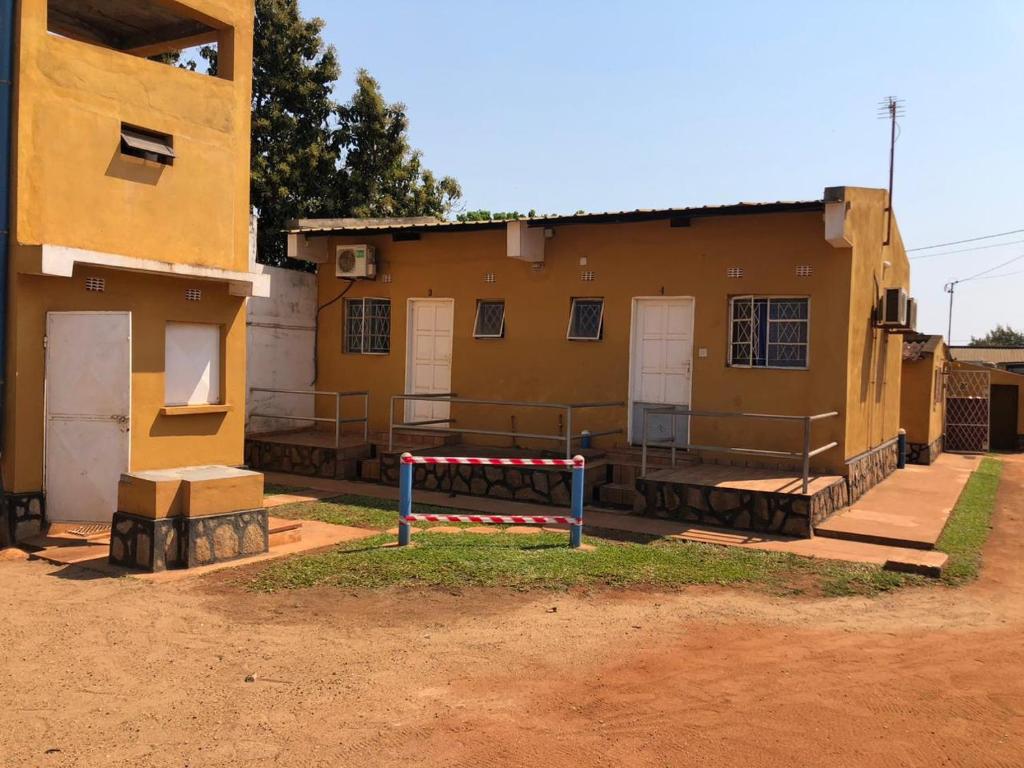 a yellow building with a sign in front of it at Residencial Meu Tio in Chimoio