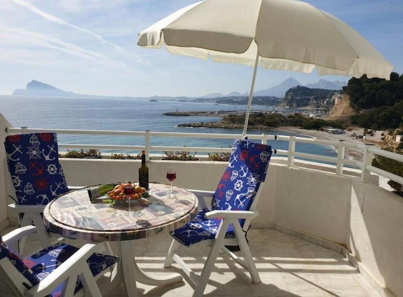 a table and chairs on a balcony with an umbrella at Panorama3 in Altea la Vieja