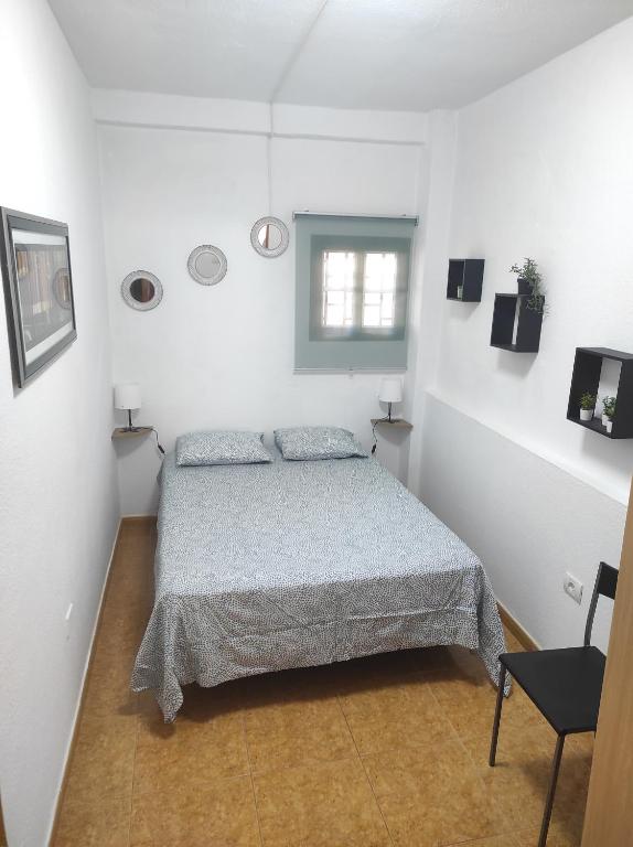 1 dormitorio con 1 cama en una habitación blanca en Casa Celeste San Isidro, en San Isidro