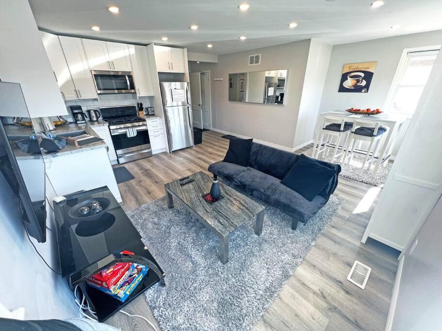 sala de estar con sofá azul y cocina en Hamilton Mountain Plaza - Smart Home - Main Floor, en Hamilton