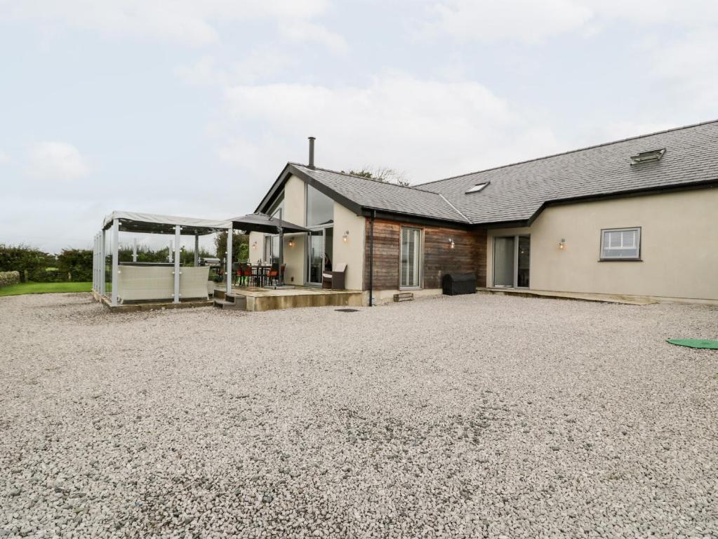 a house with a gravel driveway in front of it at Cae Sam in Pentraeth