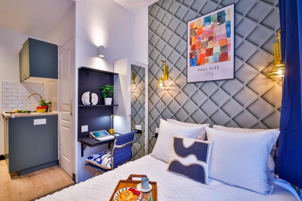 a bedroom with a bed with a blue headboard at Apartments WS Louvre - Casanova in Paris