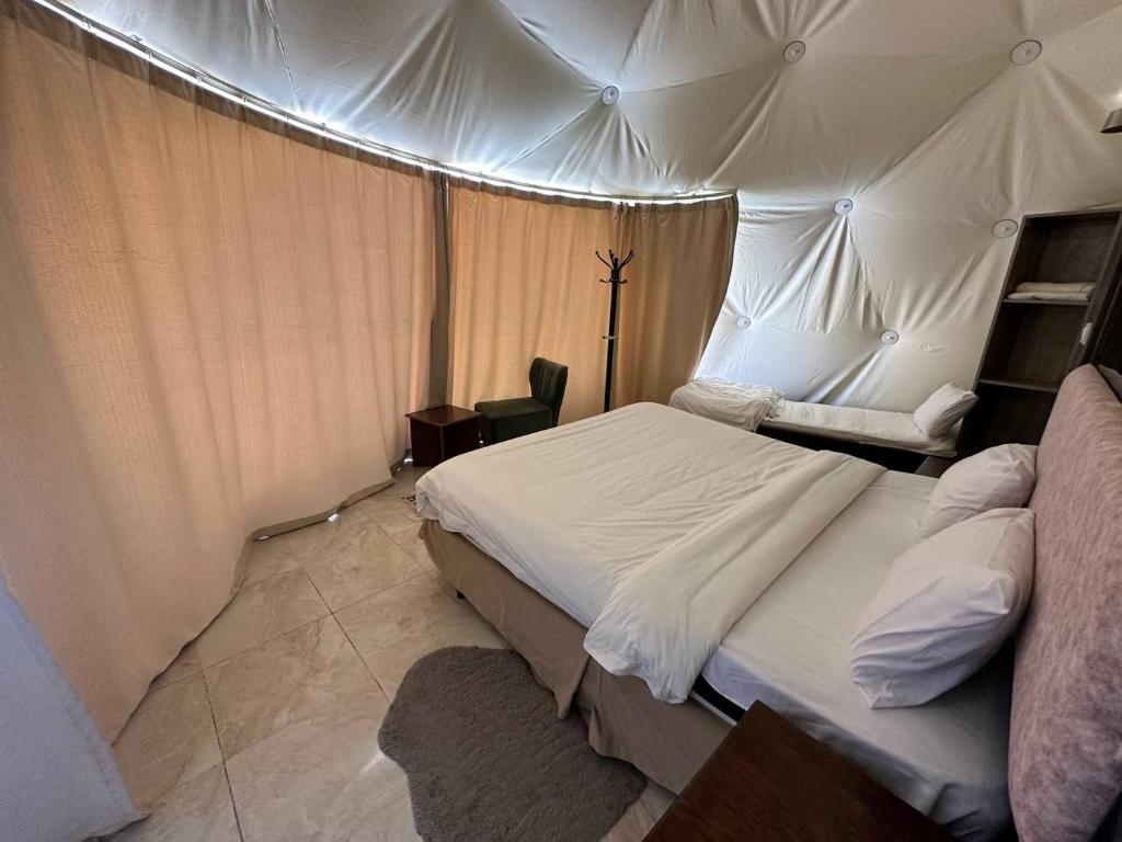 a bedroom with a large bed and a tent at Scoop Rum in Wadi Rum