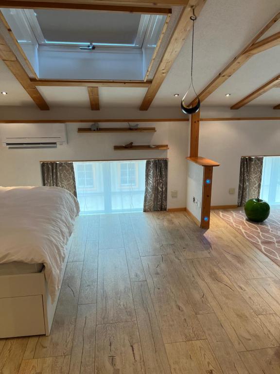 1 dormitorio con 1 cama y suelo de madera en Luxus-Loft Atrium -X-, en Rorbas