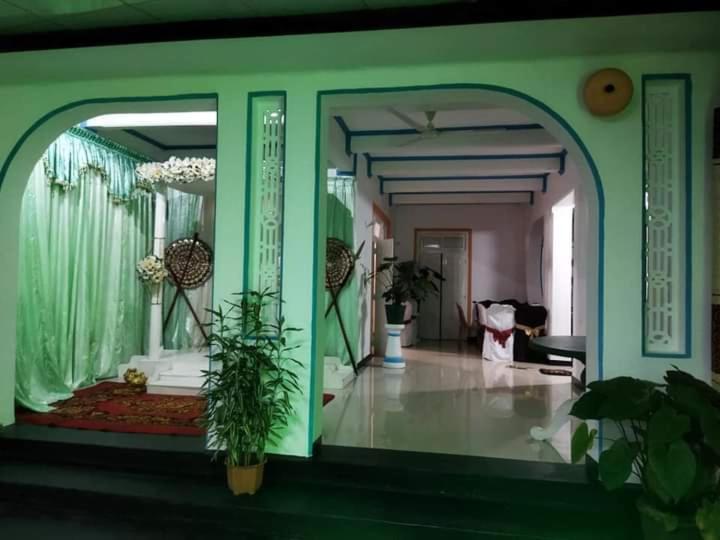 uma sala de estar com paredes verdes e uma sala com plantas em Deliya Holiday Resort em Kamburupitiya