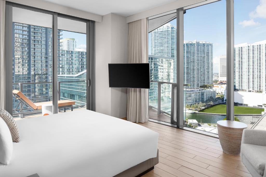 a bedroom with a white bed and large windows at EAST Miami in Miami