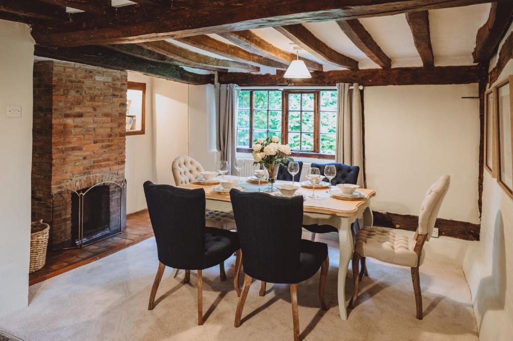 a dining room with a table and chairs and a fireplace at Laundry Cottage in Loughborough
