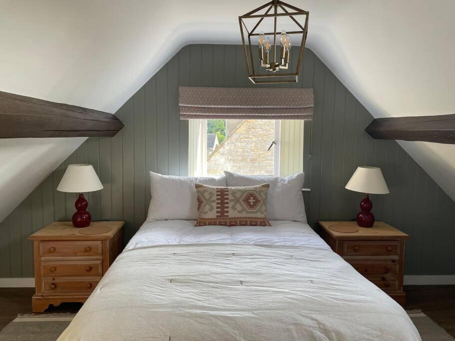 a bedroom with a large bed with two night stands at Holly Bank in Longborough