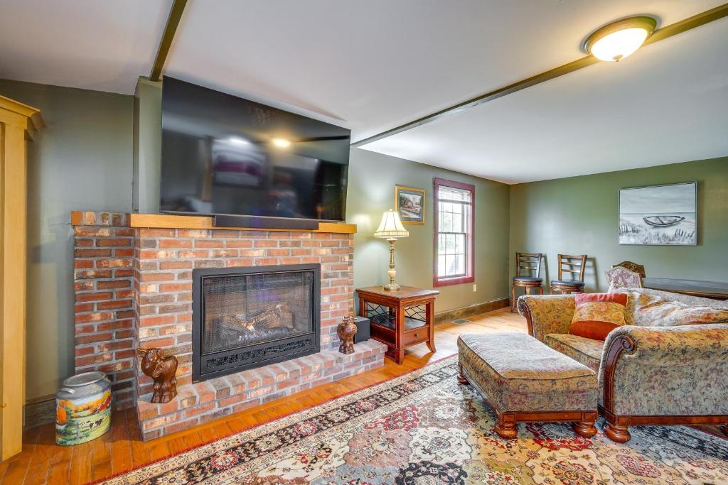 a living room with a brick fireplace with a tv at Buskirk Vacation Rental with Deck and Putting Green! 