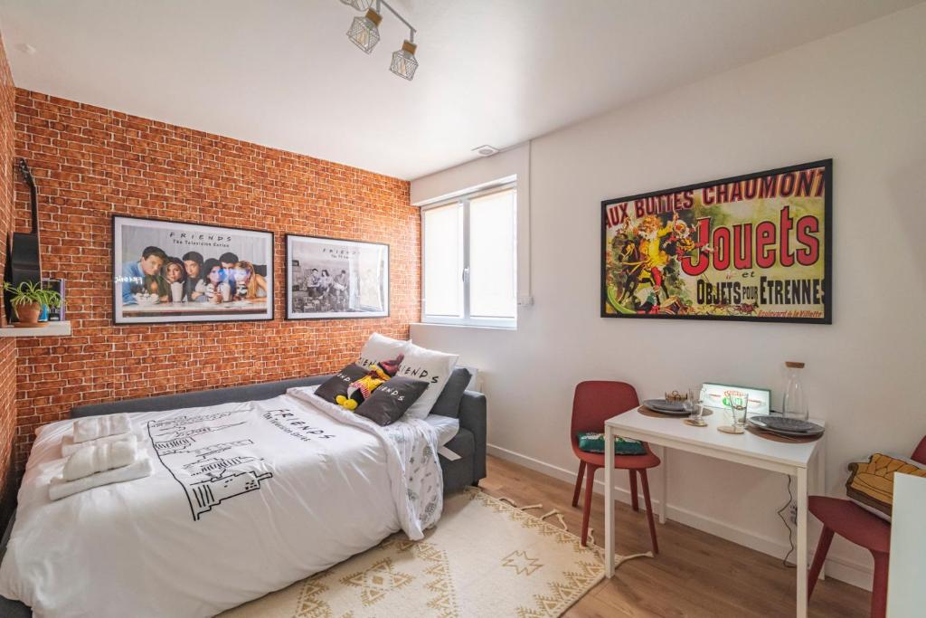 une chambre avec un lit et un mur de briques dans l'établissement ExploreReims - the Friendliest place proche gare et centre, à Reims