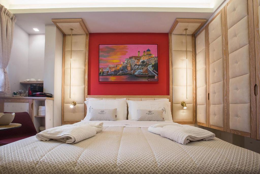 ein Schlafzimmer mit einem großen Bett mit einem Gemälde darüber in der Unterkunft Mariet Athens Boutique Spa in Athen
