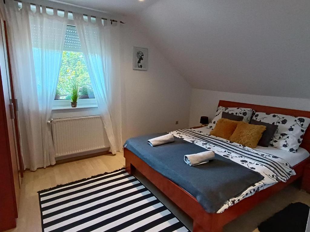 a bedroom with a bed and a window at Zala Holiday Apartman in Keszthely