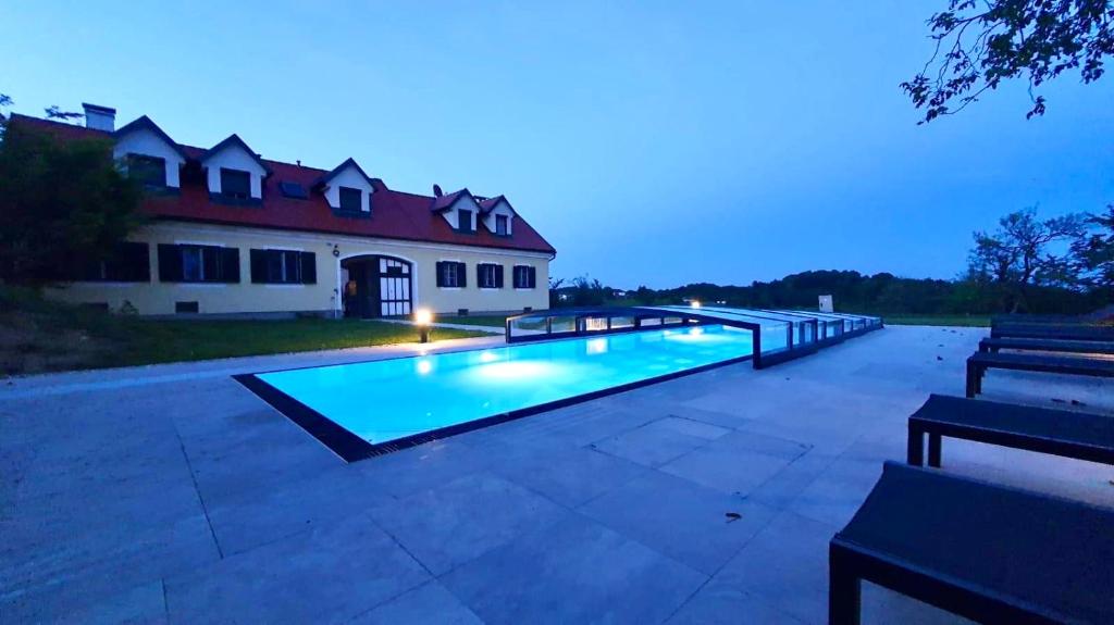 una piscina con 2 bancos frente a una casa en Landhaus dasThomas en Kenndorf
