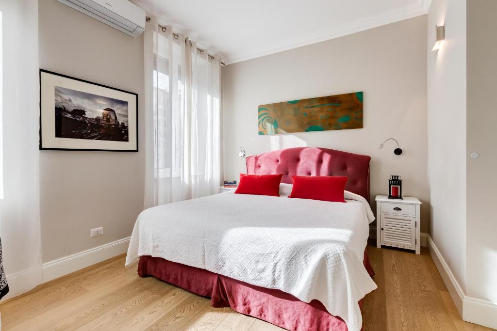 a bedroom with a pink bed with red pillows at Vatican Guest House in Rome