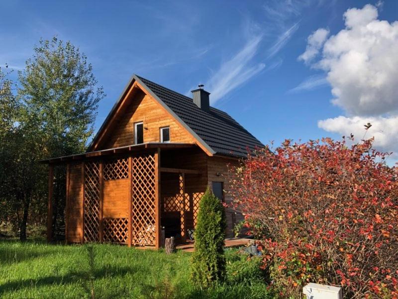 een houten huis op een groen veld bij Agroturystyka noclegi u Moniki domek drewniany in Oboźna Droga Masłów