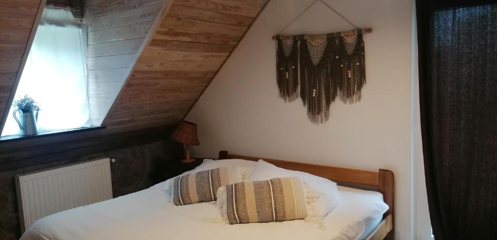 a bedroom with a bed with white sheets and a window at Janowa Góra Apartament in Stronie Śląskie