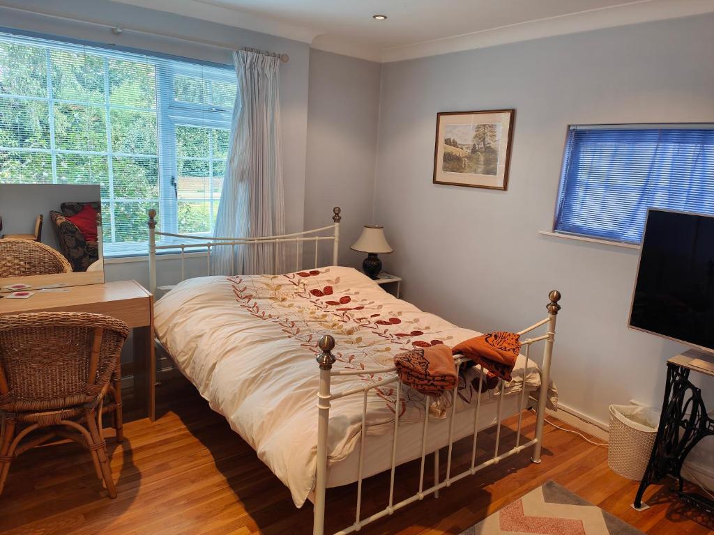 a bedroom with a bed and a desk and a window at Bracken Lodge in Merston