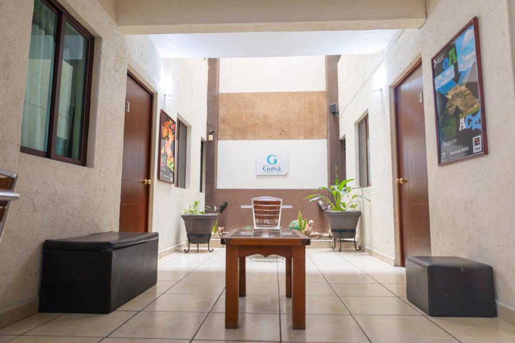 a hallway with a table and chairs in a building at Hotel Guivá Huatulco in Santa Cruz Huatulco