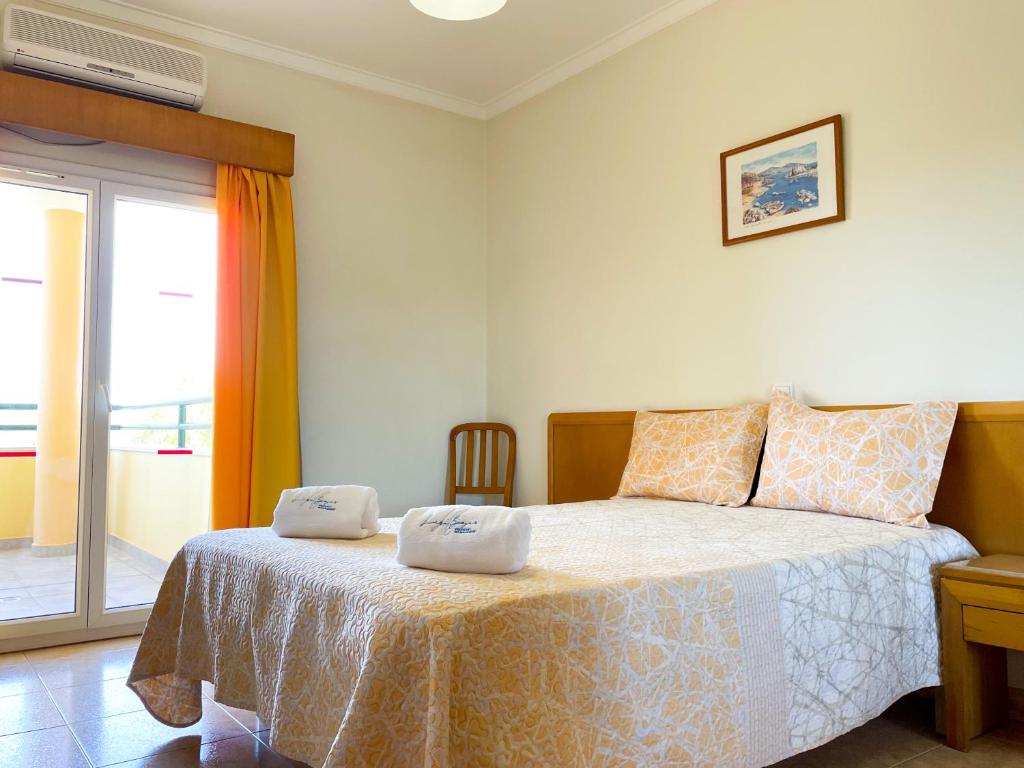 - une chambre avec un lit et 2 serviettes dans l'établissement Apartamento T1 208, Praia do Vau - Terraços do Vau, à Portimão