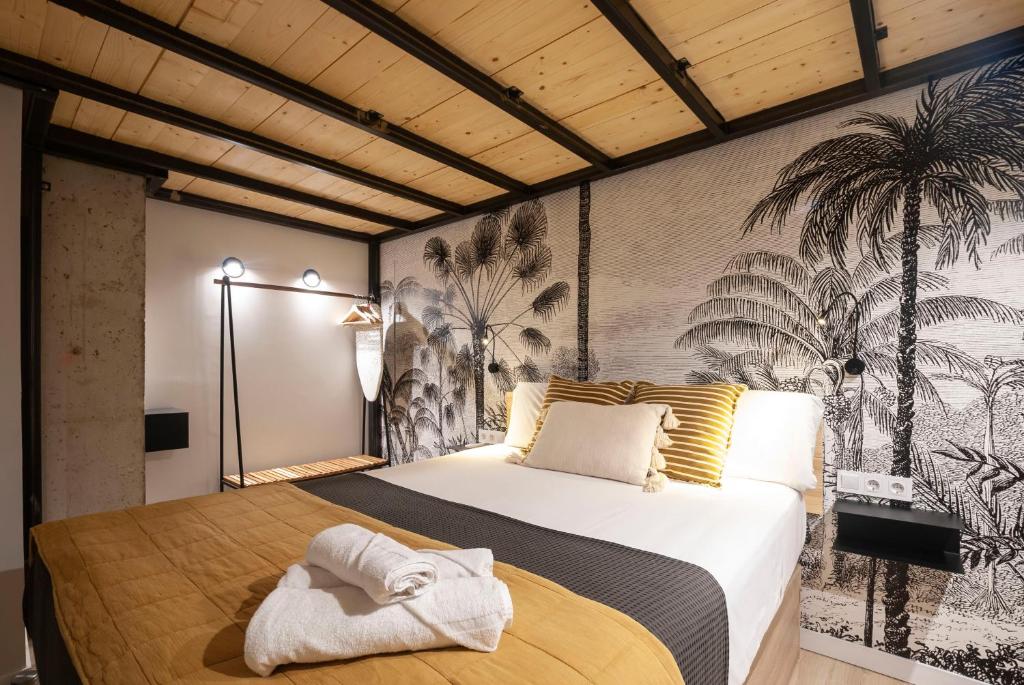 1 dormitorio con 1 cama grande y una pared con palmeras en Precioso Loft en Valencia, en Valencia