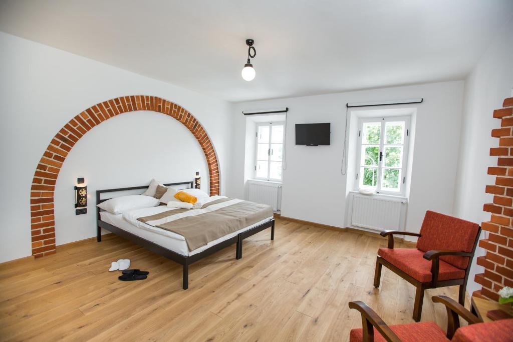 a bedroom with a bed and a red chair at Old Parish House in Bled