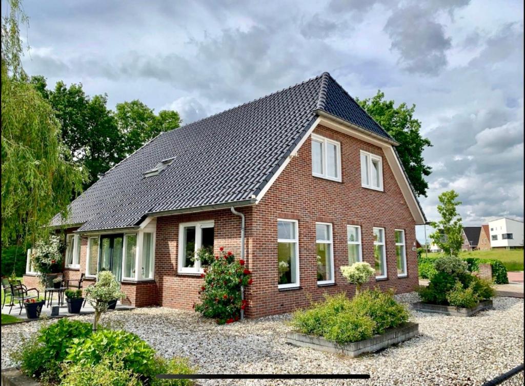 een rood bakstenen huis met een zwart dak bij Westenholte in Zwolle