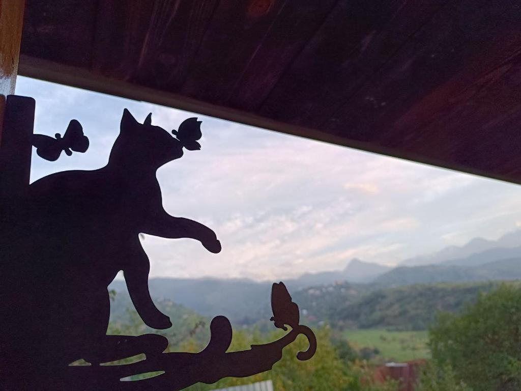 a window with a cat and butterflies on it at Янтарь Уютный горный домик in Almaty