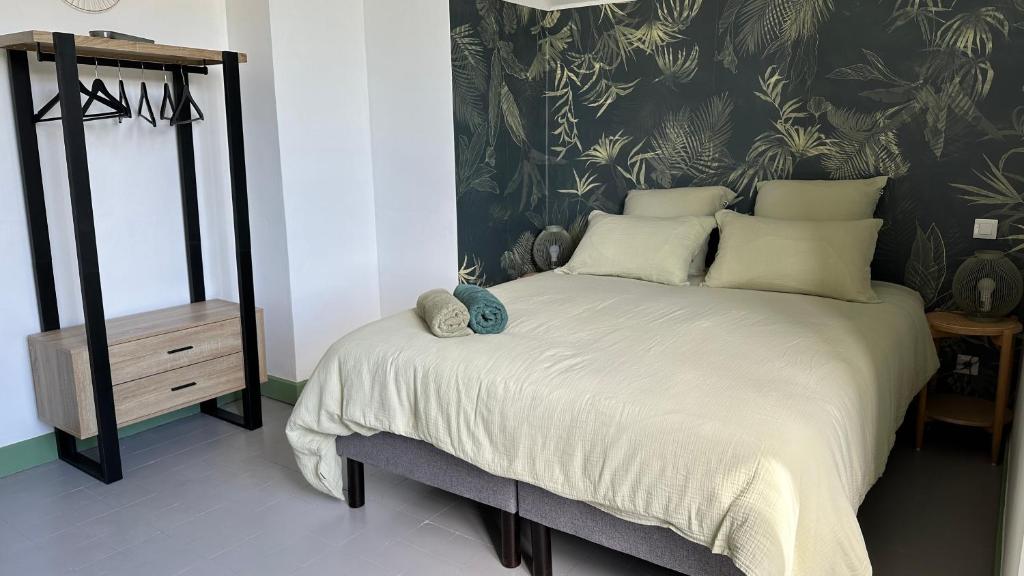 - une chambre avec un lit et du papier peint noir et blanc dans l'établissement Chambre Tropicale au Domaine de l'Aven, à Villeneuve-Minervois