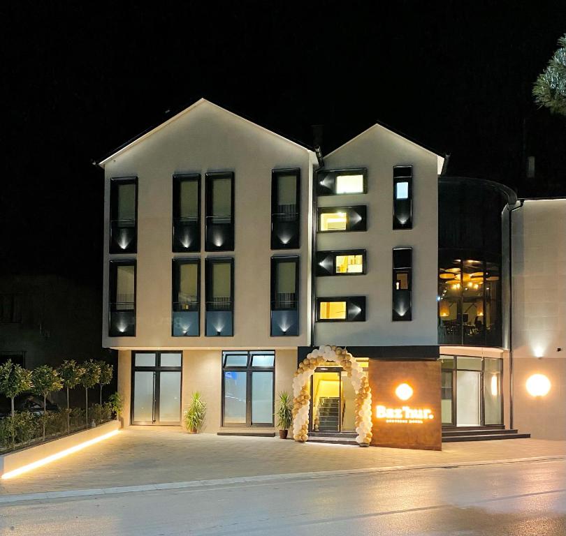 a large white building with windows at night at BAZ'HUR Boutique Hotel in Kukës