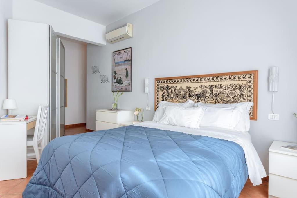 1 cama azul grande en un dormitorio blanco en L'Angolo di Ponte Vecchio, en Florencia