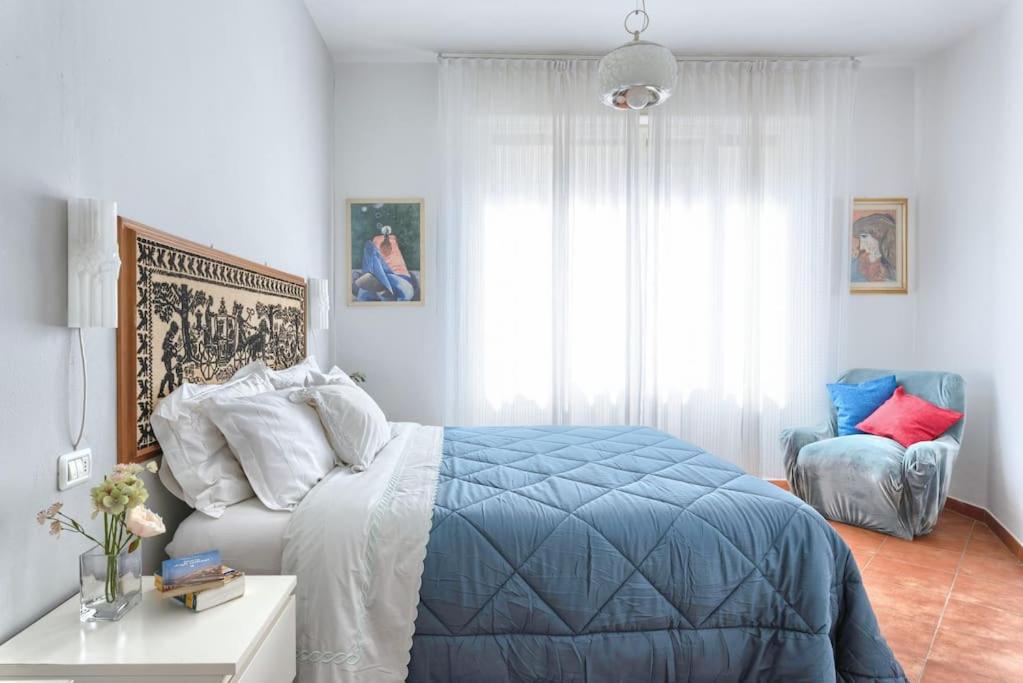 Un dormitorio con una cama azul y blanca y una ventana. en L'Angolo di Ponte Vecchio, en Florencia