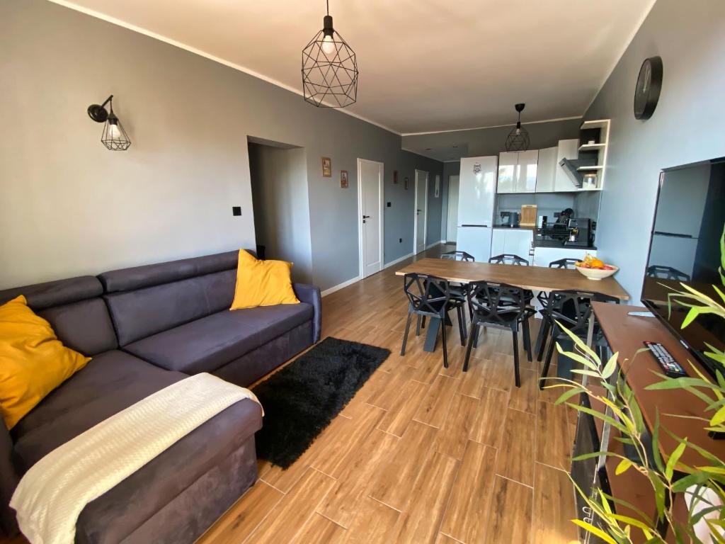 uma sala de estar com um sofá e uma mesa em Apartament Loft Krynica-Zdrój em Krynica-Zdrój