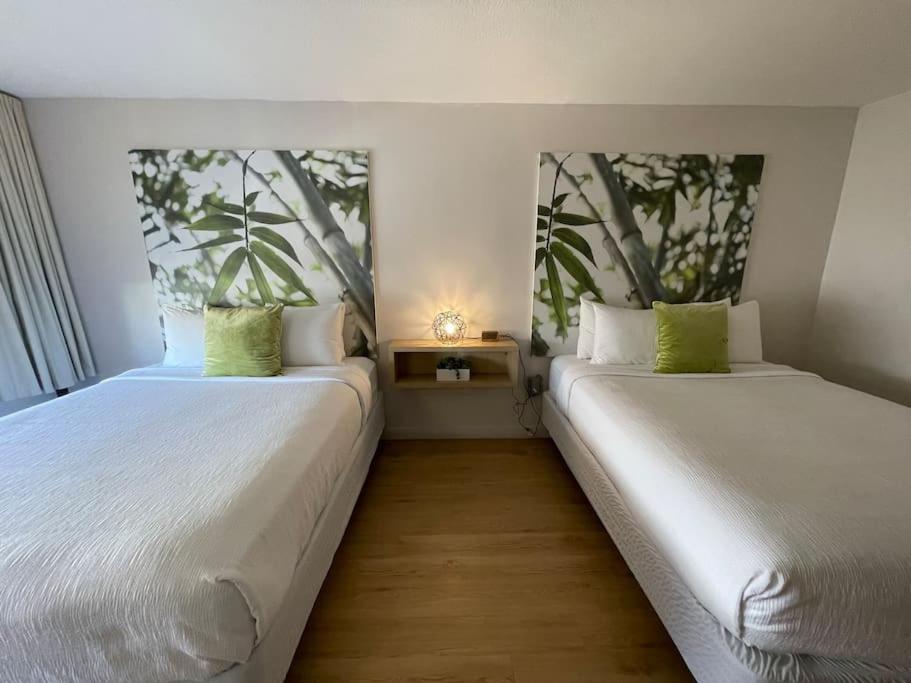 dwa łóżka siedzące obok siebie w pokoju w obiekcie Newly renovated room in cozy hotel near Disney w mieście Kissimmee