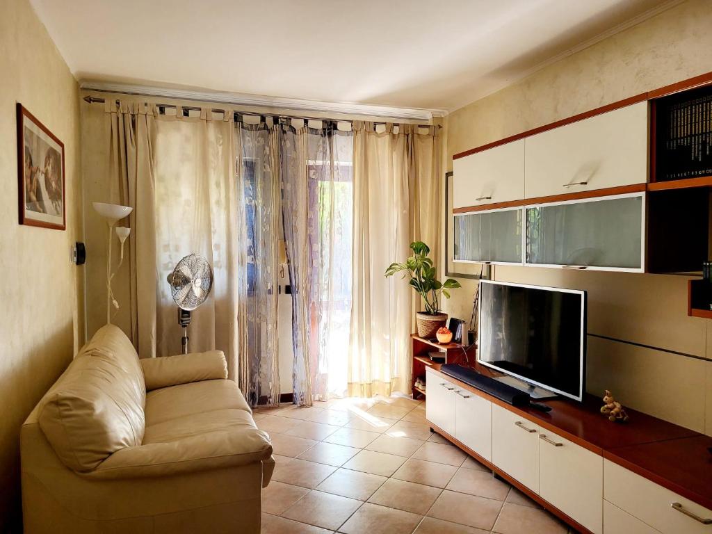 ein Wohnzimmer mit einem Sofa und einem Flachbild-TV in der Unterkunft Ryder Cup 2023 Marco Simone Golf & Country Club a 100 mt dai Campi da Golf in Marco Simone