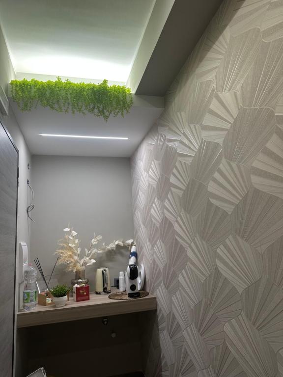 un baño con una pared con una planta verde. en B&b Sanem Luxury rooms, en Gioia Tauro