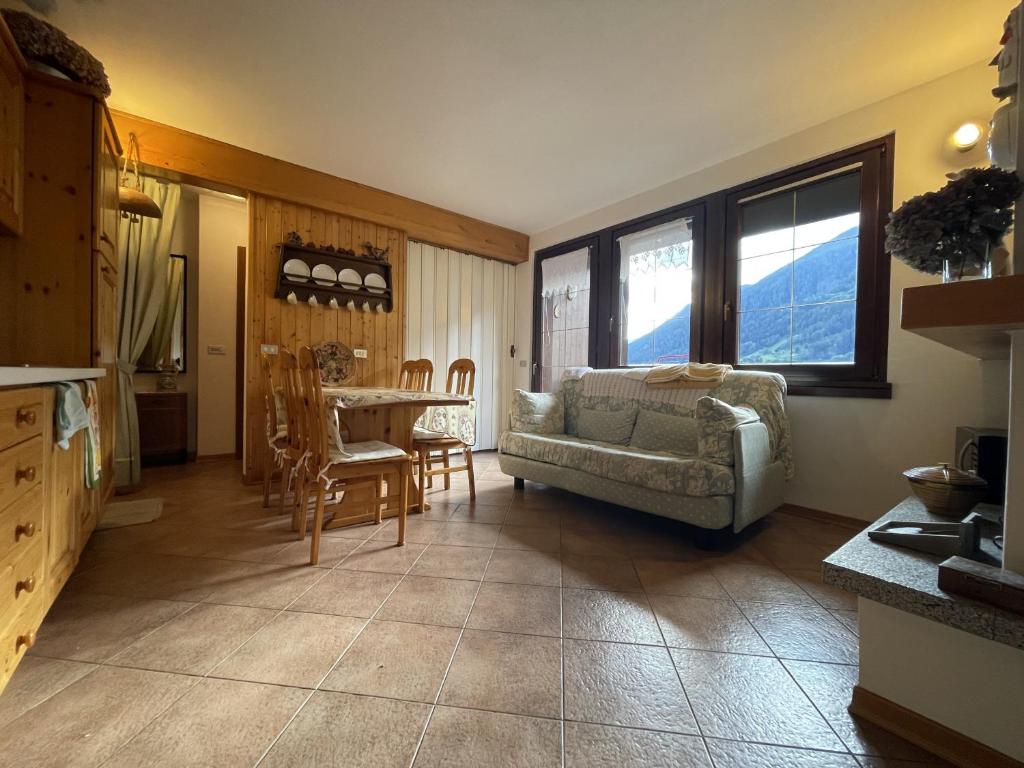 a living room with a couch and a table at Trilocale Il Cardo, Giustino in Giustino