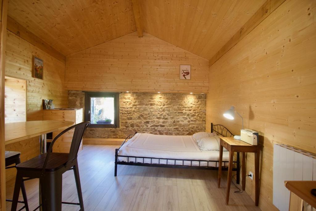 a bedroom with a bed in a wooden room at le dixneufcentvinschiroubles in Chiroubles