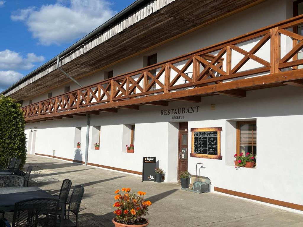 a restaurant with a wooden bridge on the side of a building at Penzion Golf Luby 