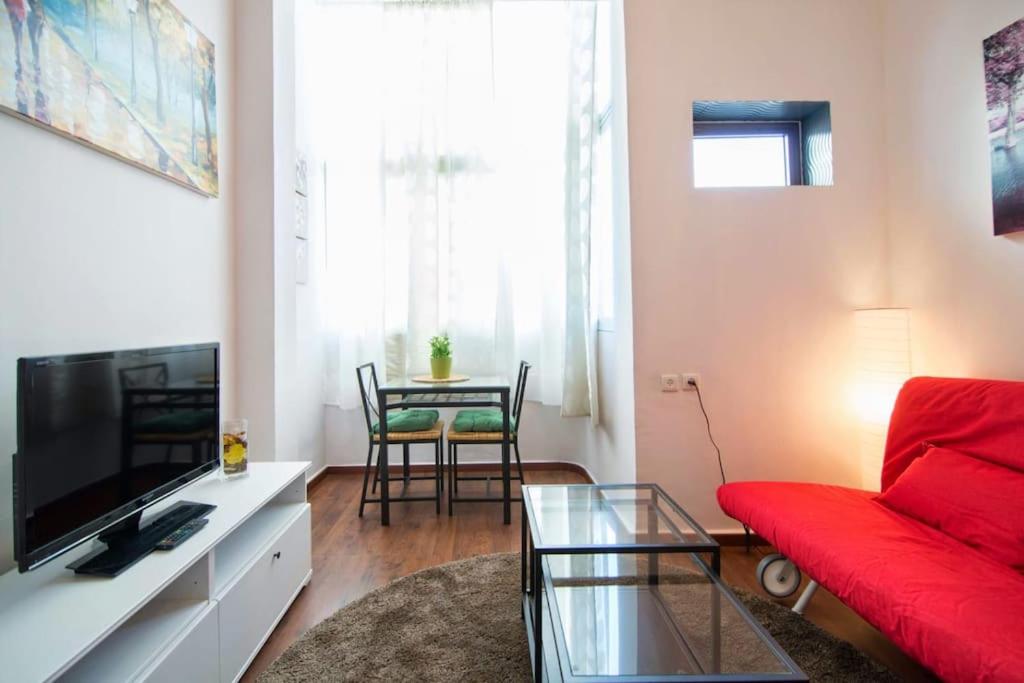- un salon avec un canapé rouge et une table dans l'établissement Gallery studio apartment, à Tel Aviv