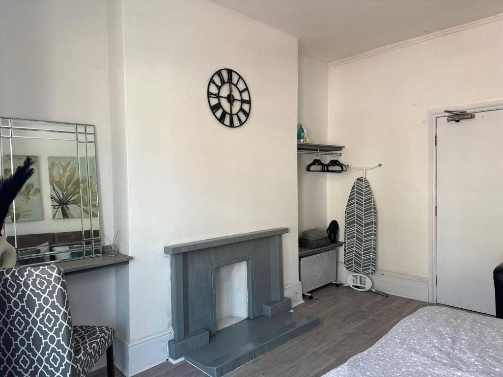 a living room with a fireplace and a clock on the wall at Captivating 1-Bed Apartment in Newport in Newport