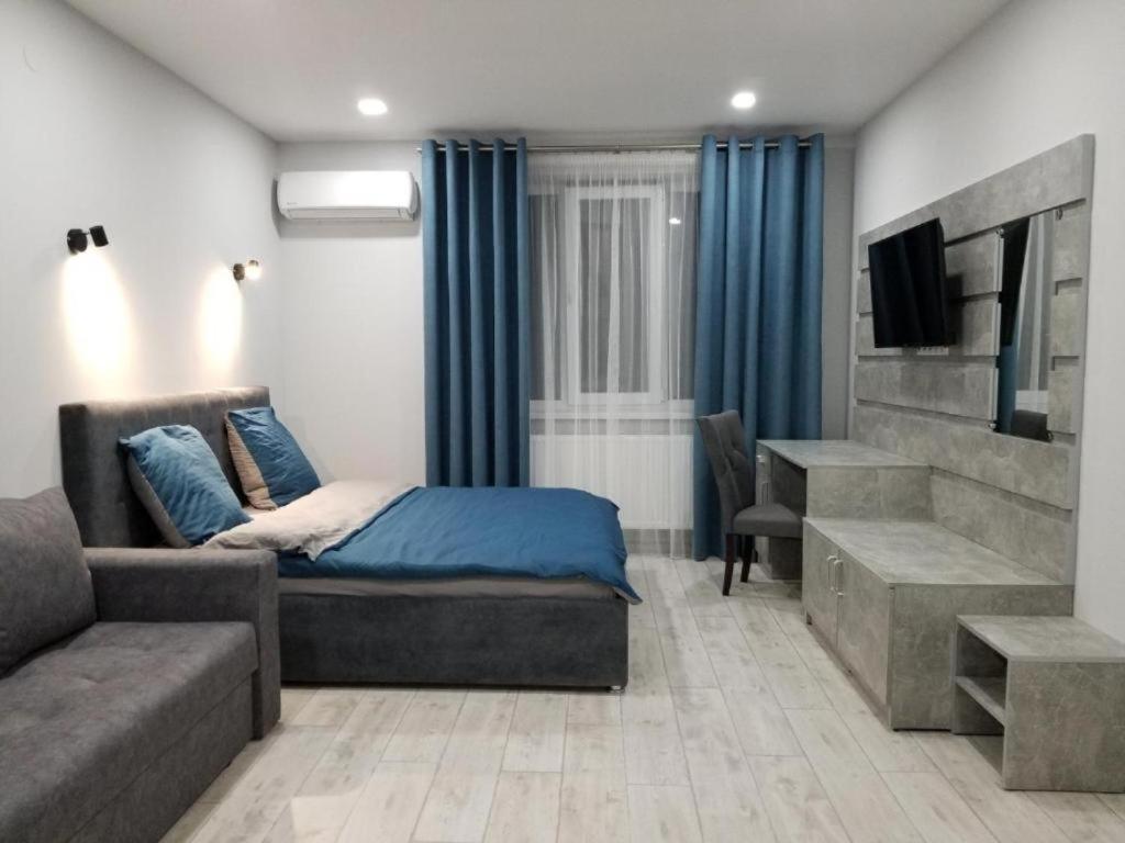 a bedroom with a bed and a couch and a tv at Lux na Druhetiv in Uzhhorod