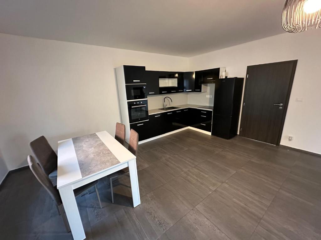cocina con mesa, mesa blanca y sillas en Byt apartman 73m2 for 4people ALL NEW! 2023 en Praga