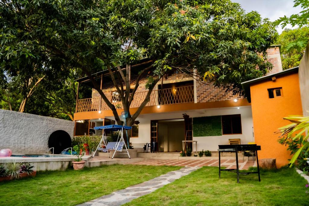 una casa con un albero nel cortile di Cabaña Casa Lila a Santa Marta