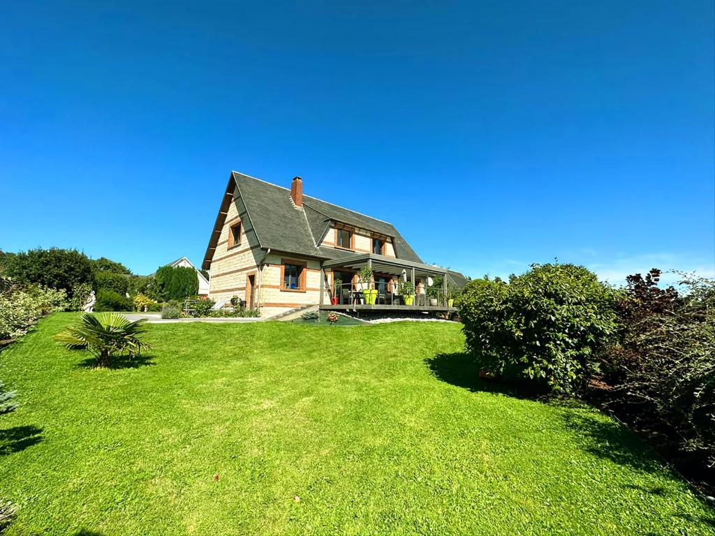 ein großes Haus auf einem grünen Rasen in der Unterkunft Maison proche Étretat in Le Tilleul