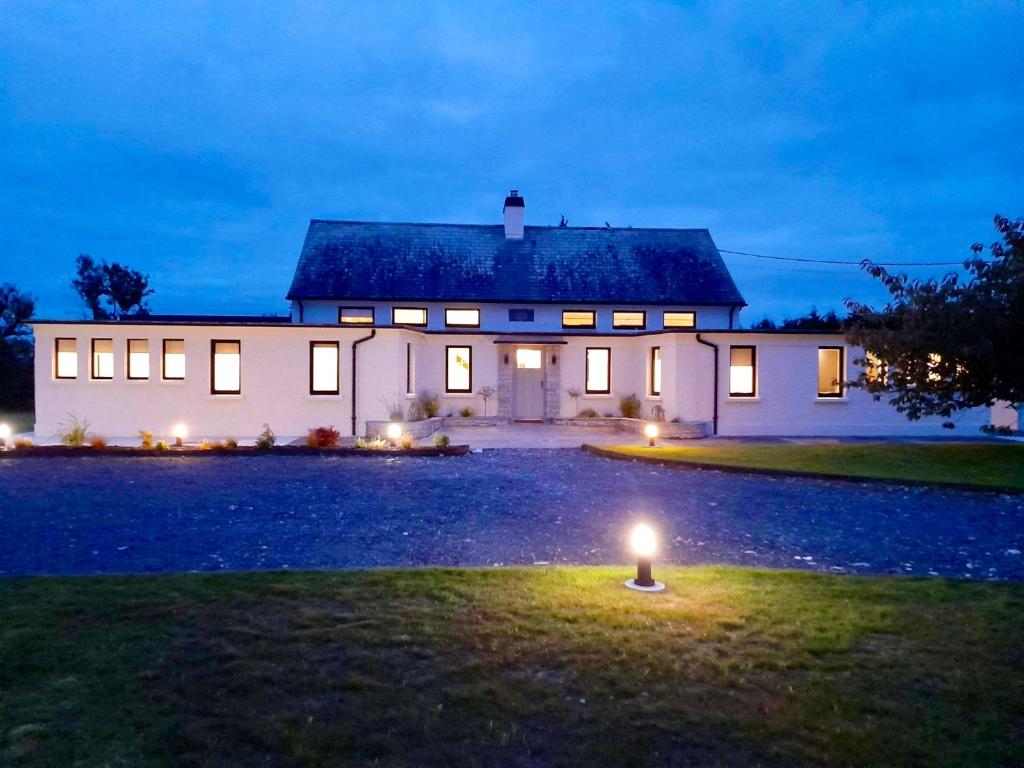 una gran casa blanca con una luz en el césped en Dillon School House - Luxury in the countryside, en Roscommon
